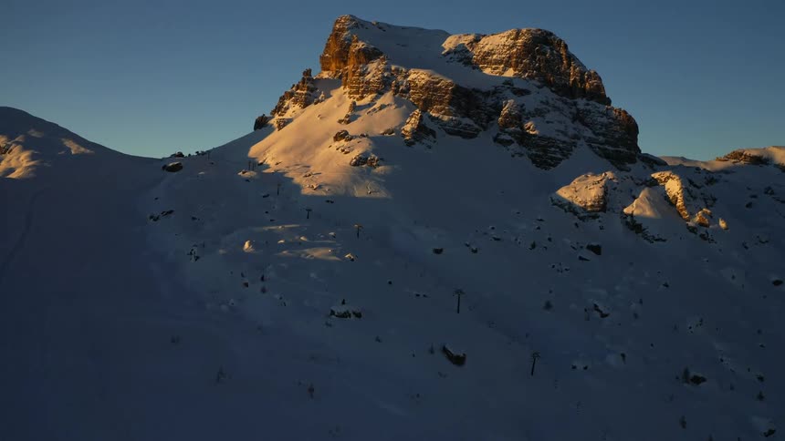 A snow covered mountain ridge under a clear blue sky