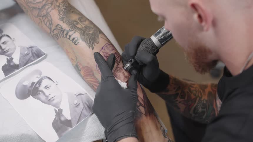 Tattoo artist uses an old timey vintage picture of a soldier for a tattoo on a clients leg