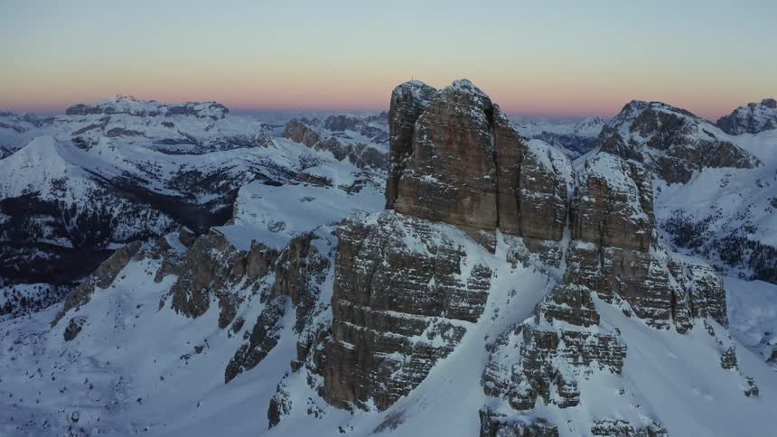 The sun rises over a snow covered mountain range