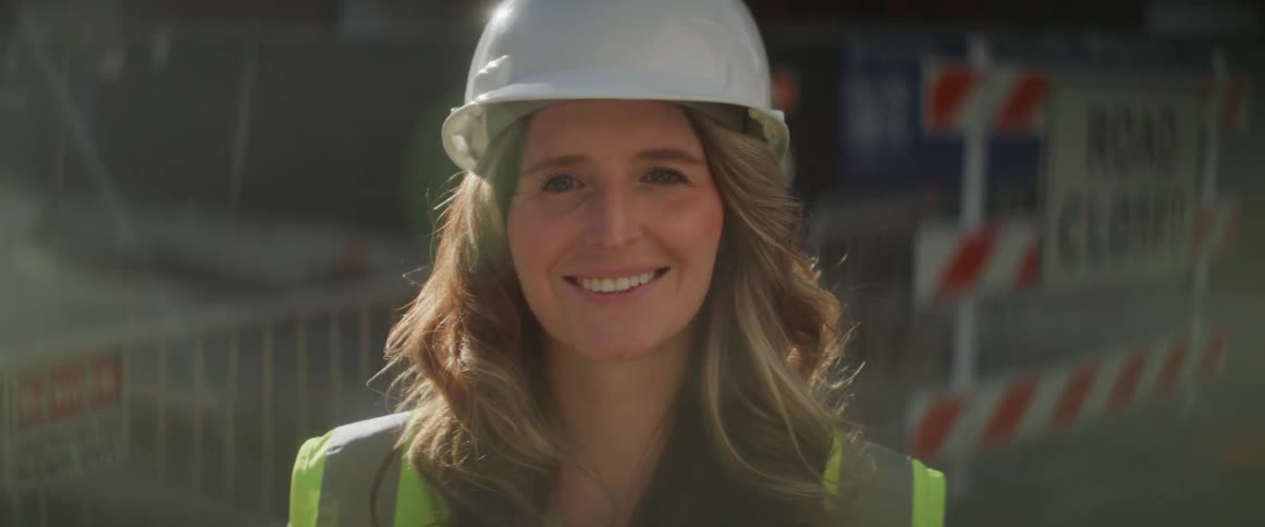 A construction worker wearing a hardhat smiles