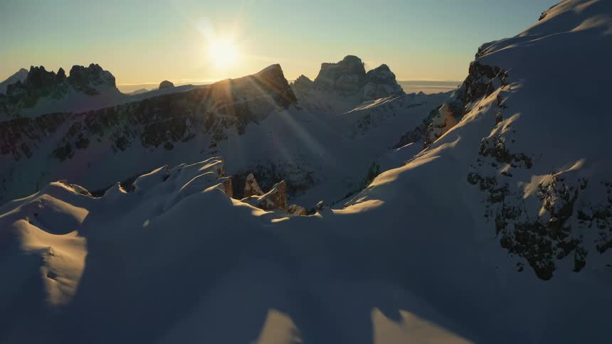 Sunlight shining over snowy mountains in the wilderness on a winter morning