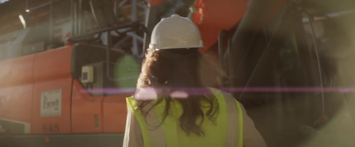 A construction worker walks toward a bulldozer on a construction site