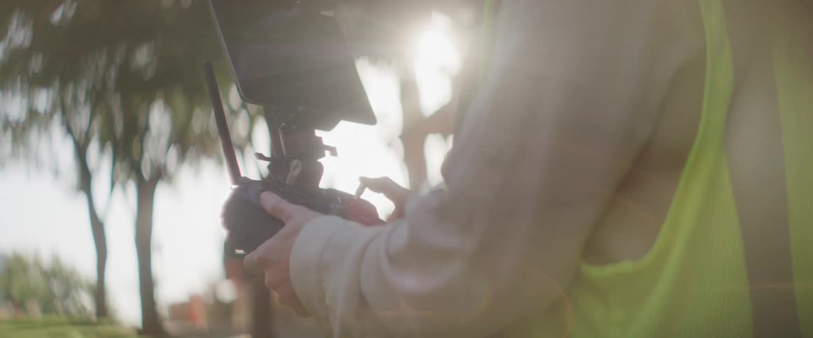 A person using a drone controller outdoors