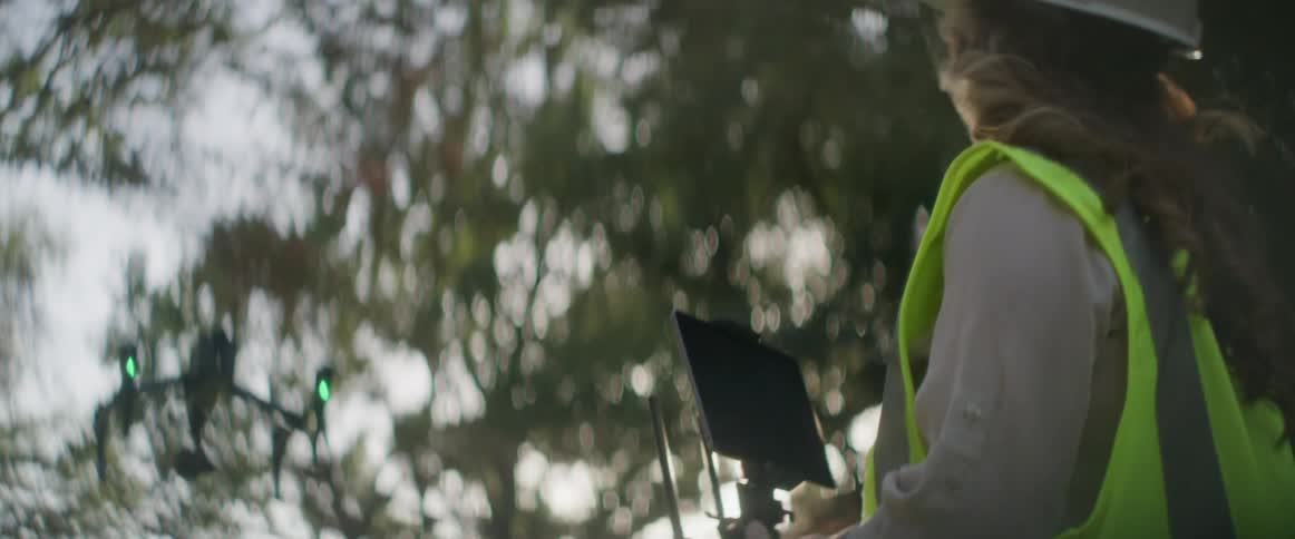 A woman is flying a drone on a construction site