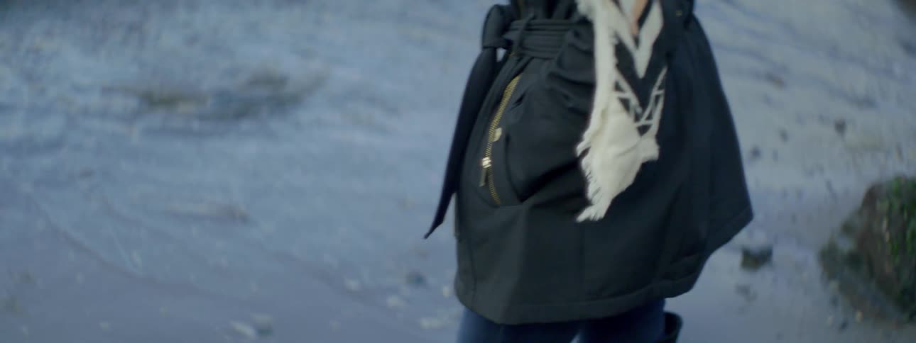 A woman walks down a beach