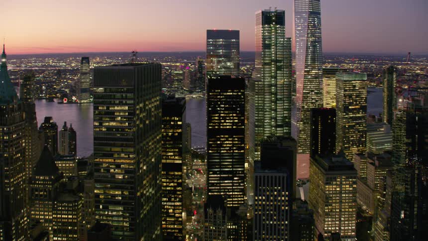 City buildings and skyscrapers are lit up with lights at night