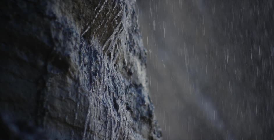 Heavy rain adds to water falling down the side of a rock wall