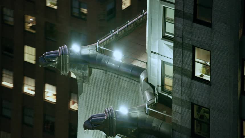 An aerial view orbiting close to a tall building in a metropolis at night