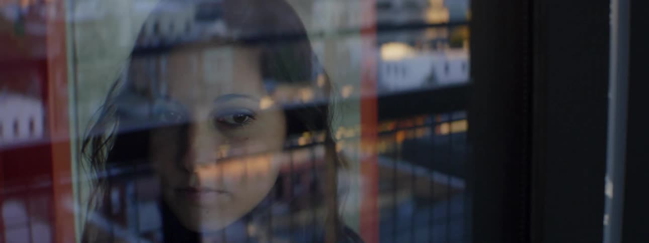 A woman is looking out a window inside