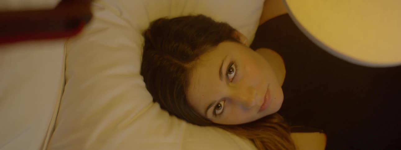 Woman laying on a bed looking upward