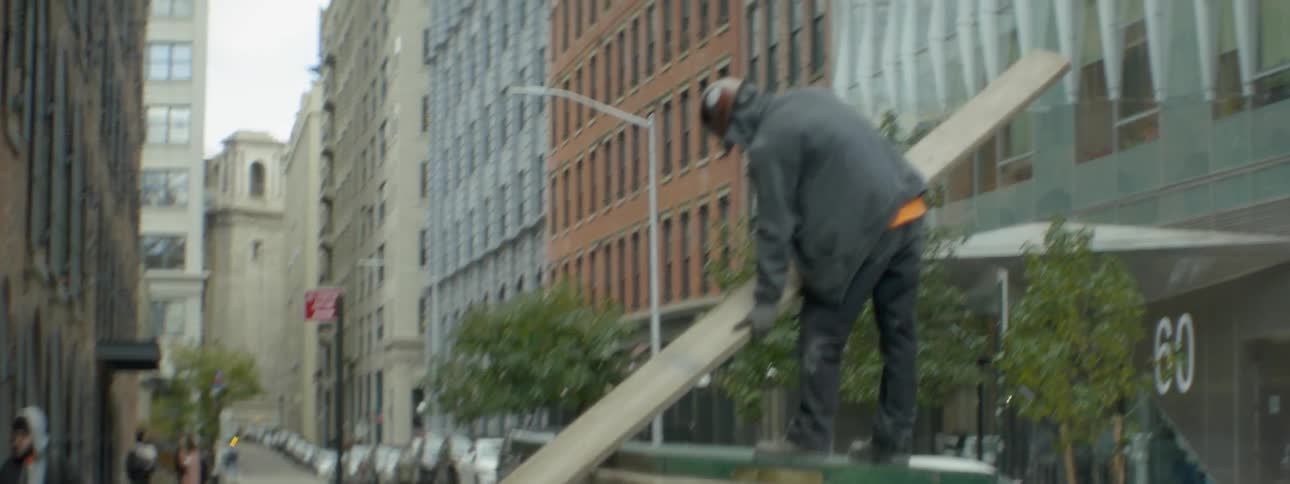 A man pulls up a wooden plank onto a truck