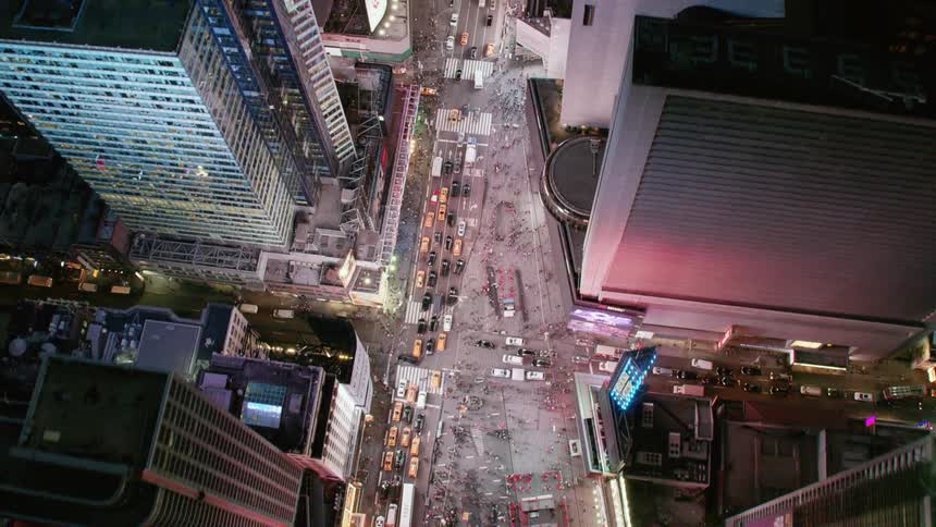 City lights and neon lights illuminate busy city streets in downtown among skyscrapers at night