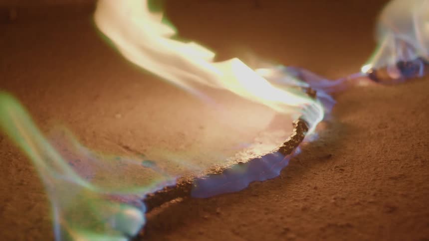 An electrical cord on a floor is on fire