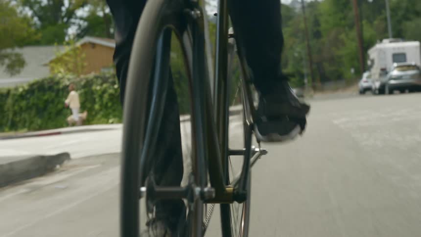 A person pedals a bike through a residential area