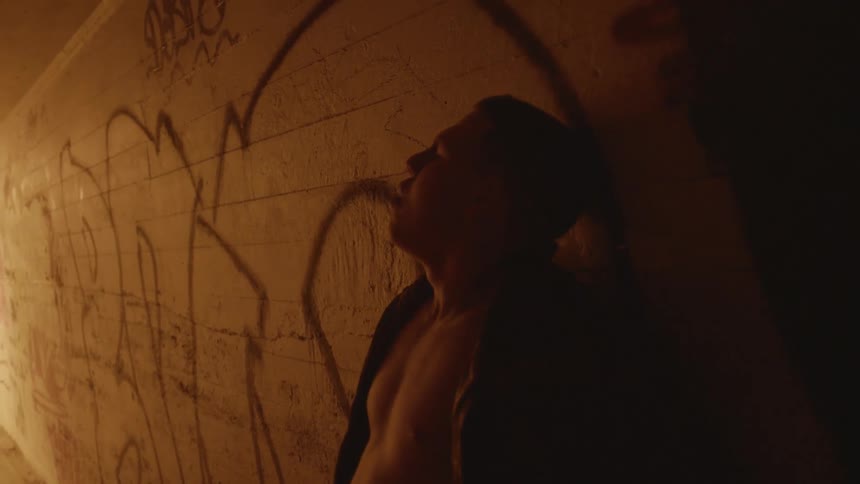 A man crying walking through a tunnel