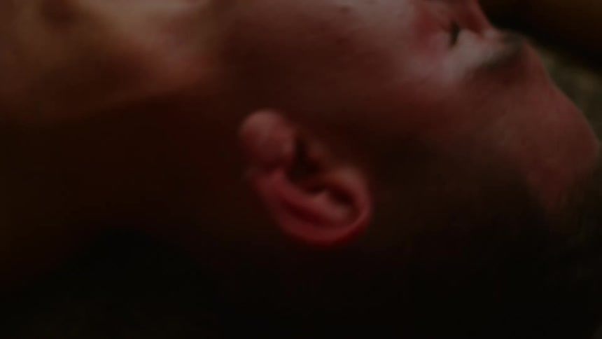 Man lies on floor shaking and trembling with eyes closed
