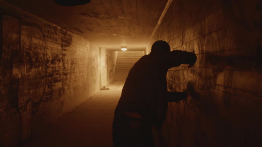 Silhouette of a weak man dragging himself through a dark hallway