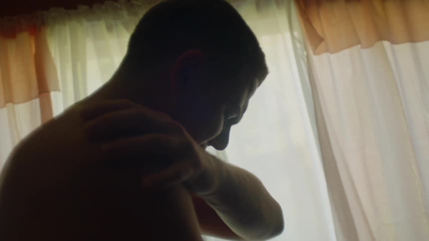 A man is struggling in the room jerking back and forth