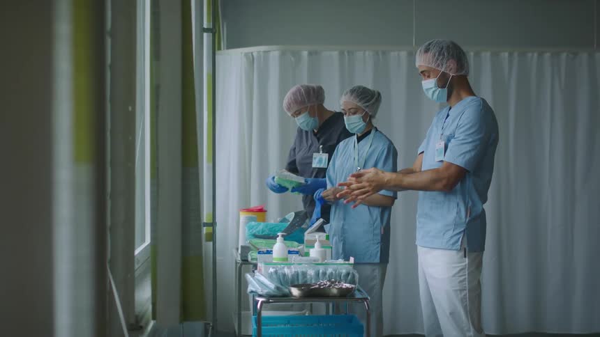 Group of nurses cleaning their hands on a hospital room