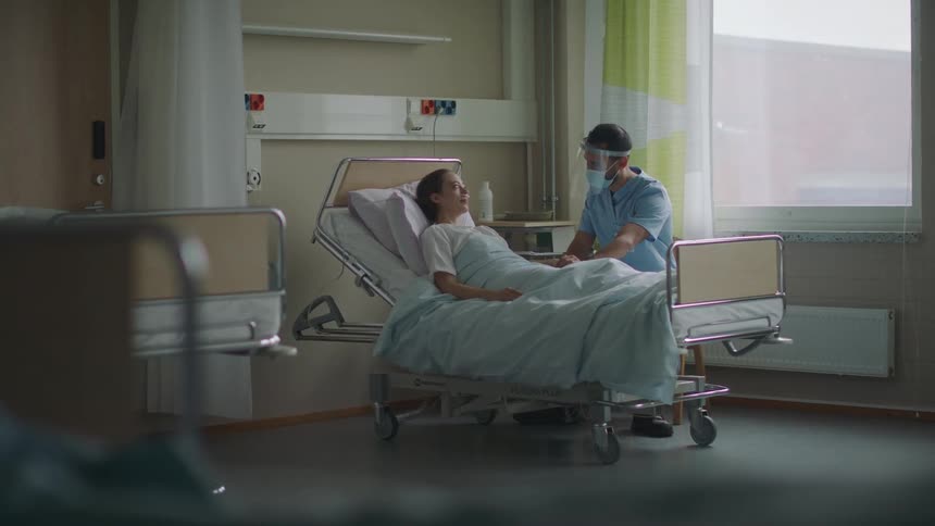 A doctor talks to a patient then leaves the hospital room