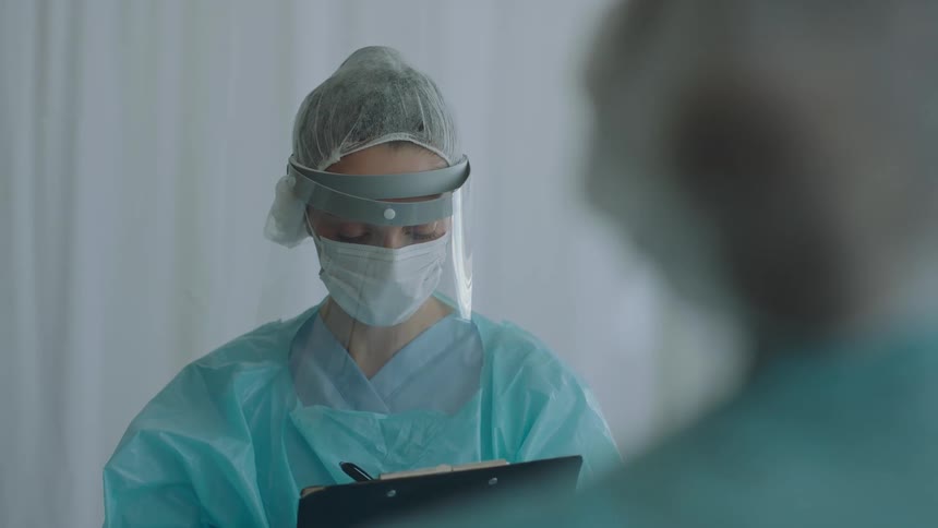 A doctor writing notes on a clipboard