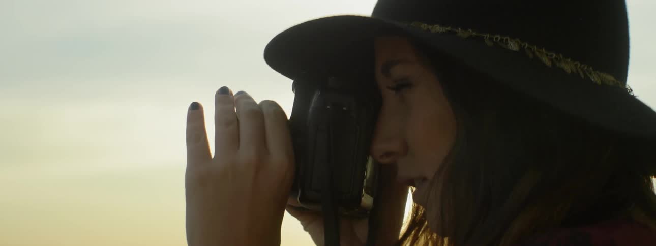 A woman adjusts a camera