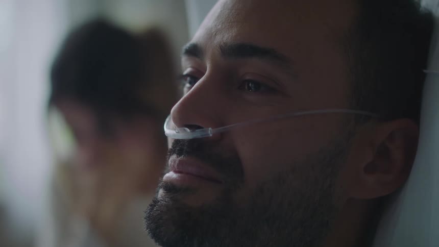 A patient is laying in bed crying