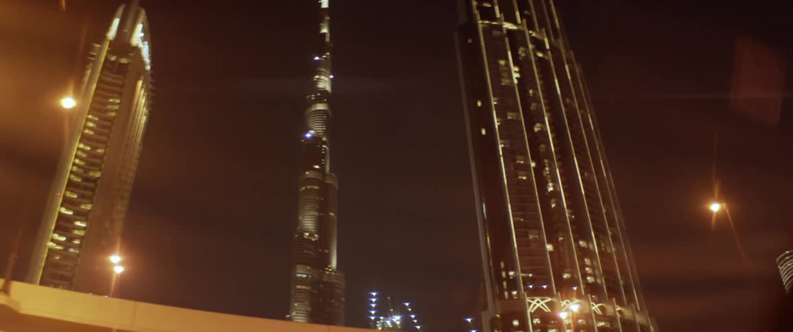 Lights are shimmering on tall buildings in a city at night