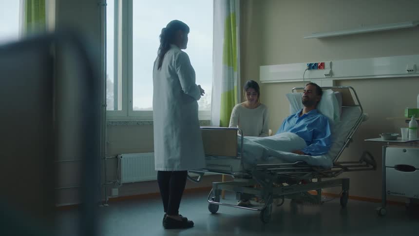 Doctor delivers bad news to patient sitting in a hospital bed