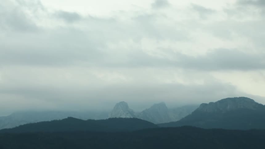 Dense fog obscures the top of a mountain range
