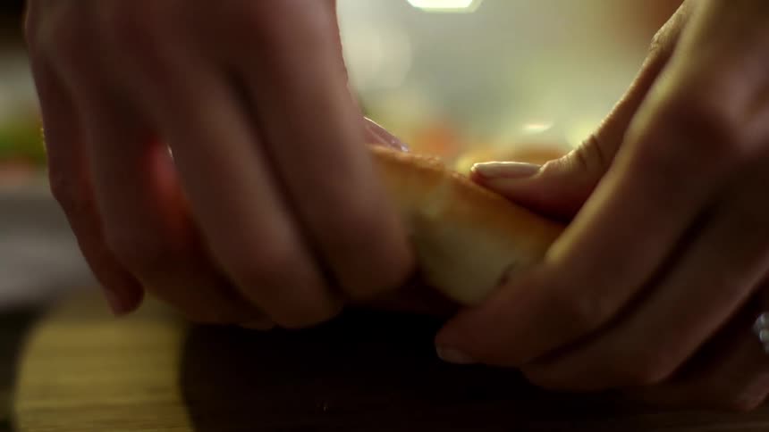 A person tears off a piece of bread