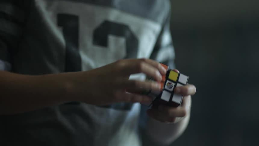 A person is playing with a rubiks cube