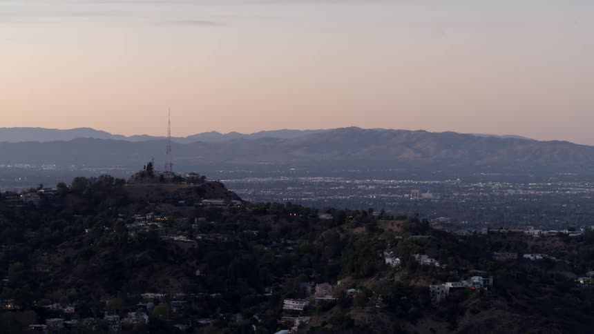 The sun sets over the Hollywood Hills with the San Fernando Valley in the background