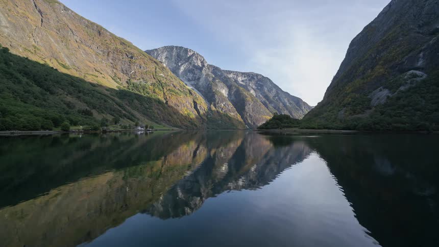A time lapse of clouds passing over a river flowing in a mountain range