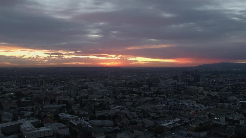 The sun is setting behind the heavy clouds over East Los Angeles