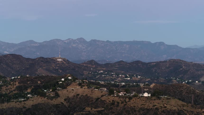 The Hollywood Hills and Hollywood sign loom in the distance at blue hour