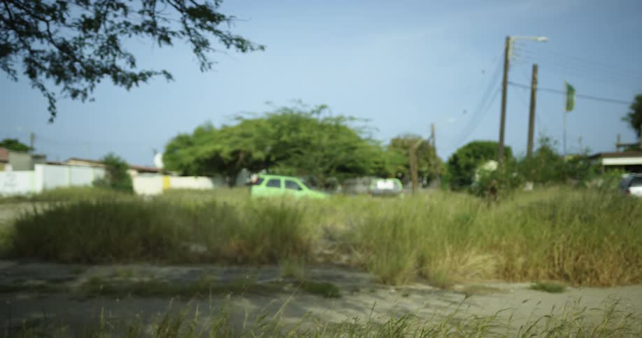 A young man is sitting on a bicycle in a neighborhood then starts riding away