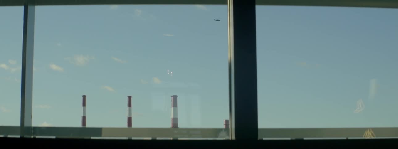 A helicopter flies past a building