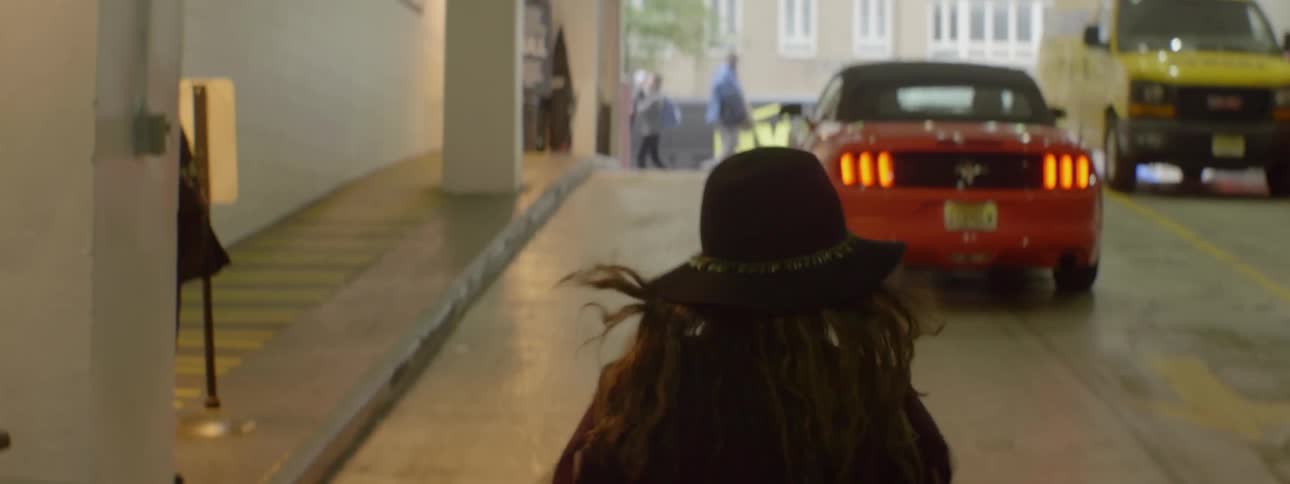 A woman is walking out of a garage towards the street