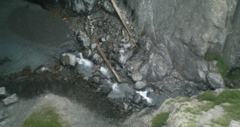 Water flows in narrow white water rapids between steep cliffs