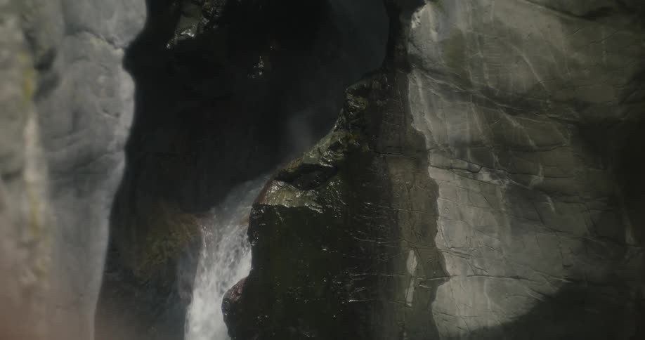 Waterfall flowing down a crevasse on the cliff side of a mountain