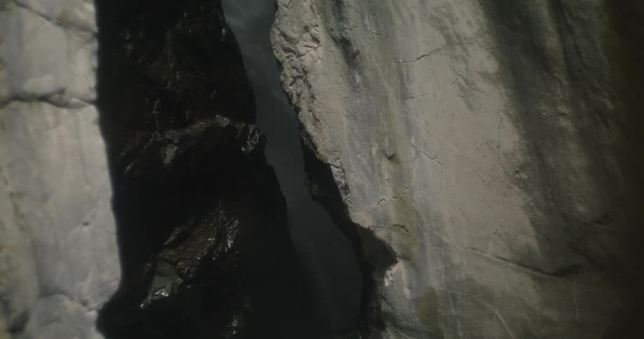 The water flows through the crack in the rocks