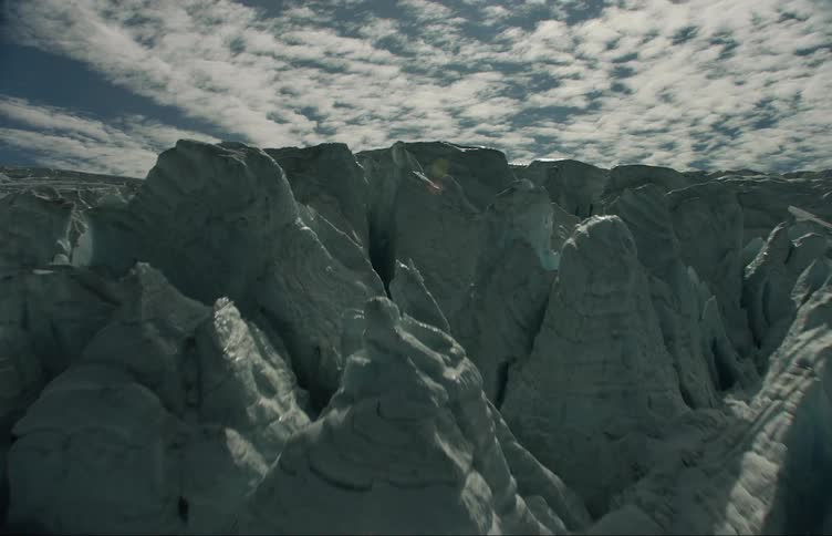 Ice glaciers and rocks with the sky and clouds in the background