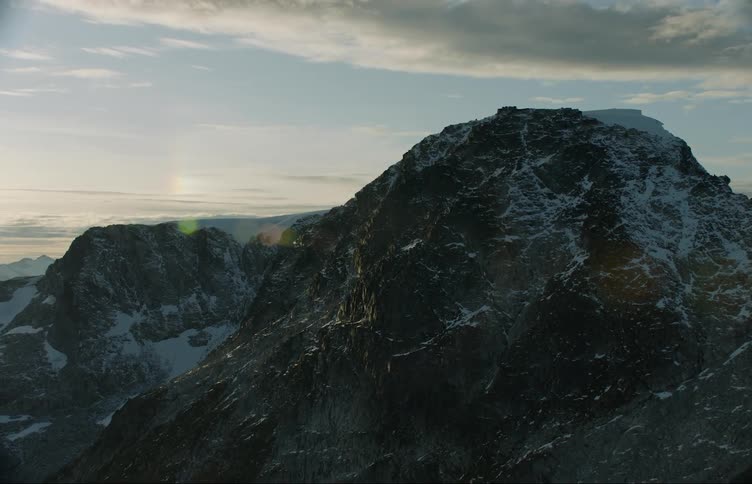 Aerial view of the snow covered peaks of a mountain range at evening