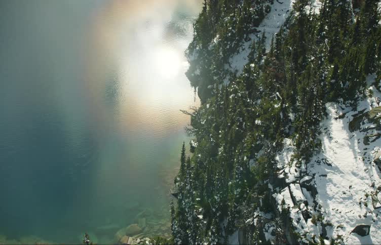 Aerial view of a lake in the snow covered slope of the mountains