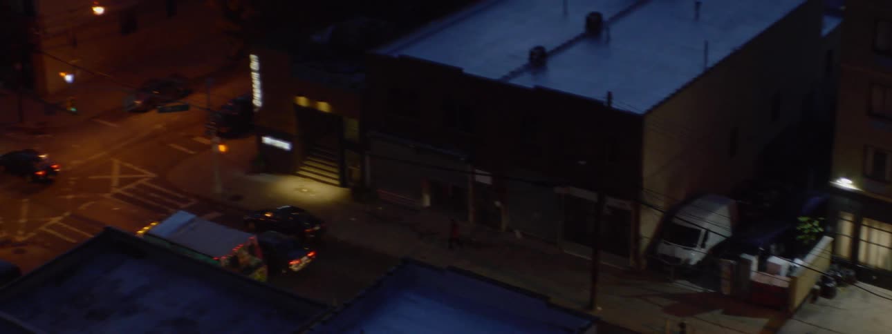 A taxi pulls away from a hotel at night