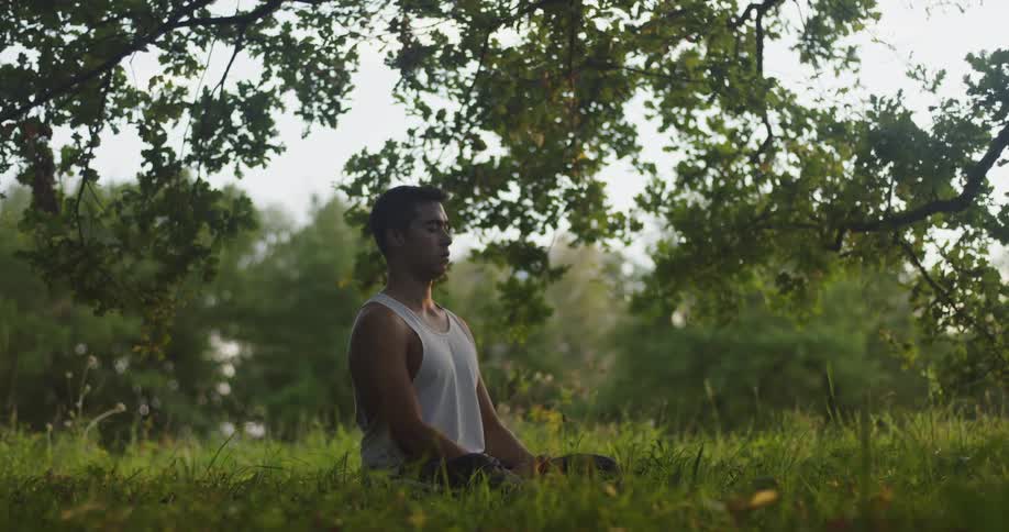 A man is meditating on the field