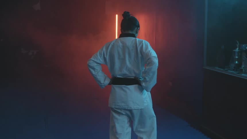 A woman walking in a karate outfit