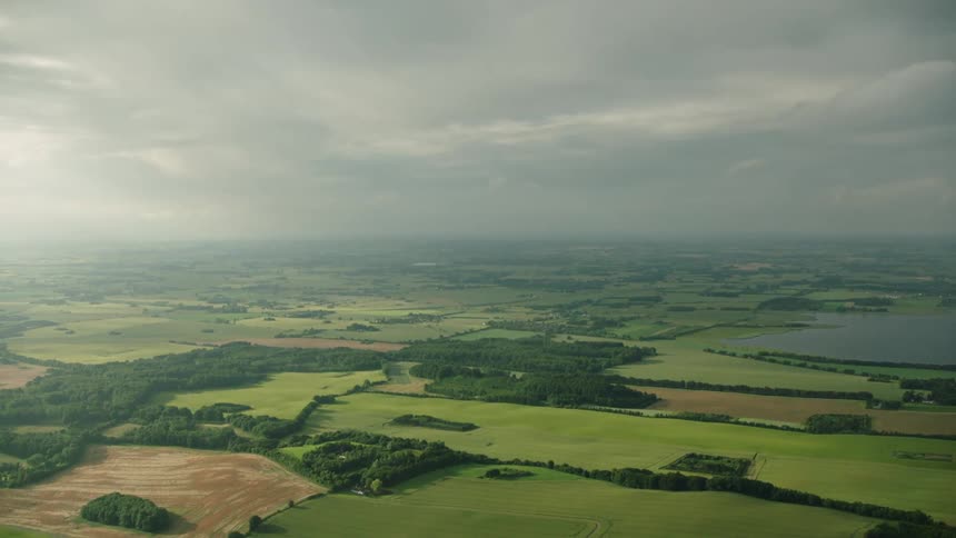 Aerial view of green farmland under the clouds at evening
