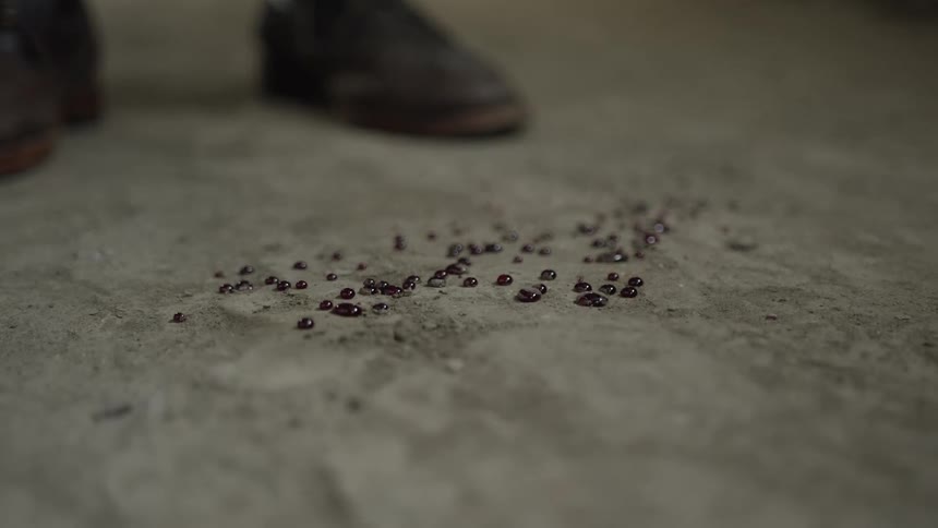 A person dripping blood on the ground